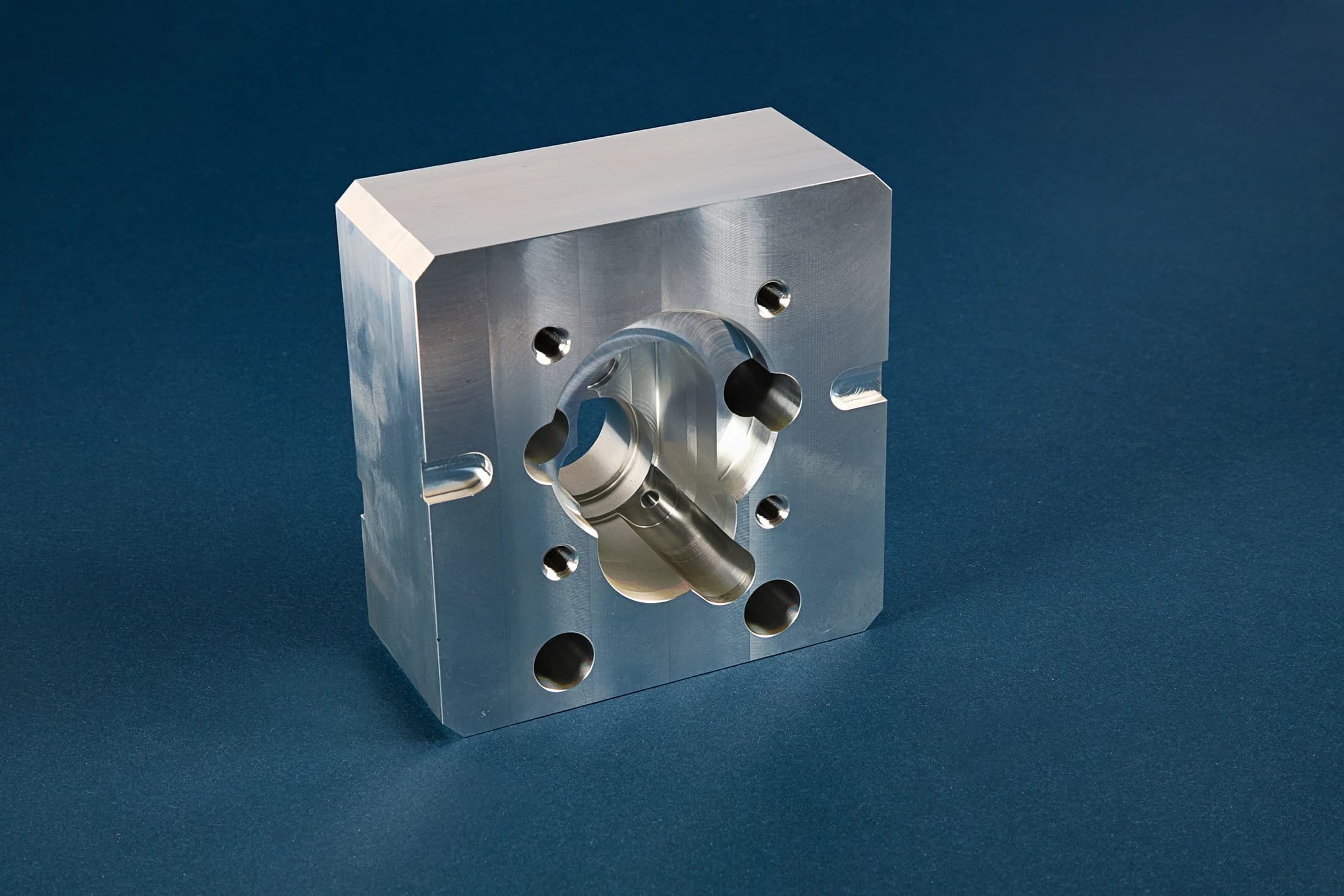 CNC Experts housing block with a central opening and holes