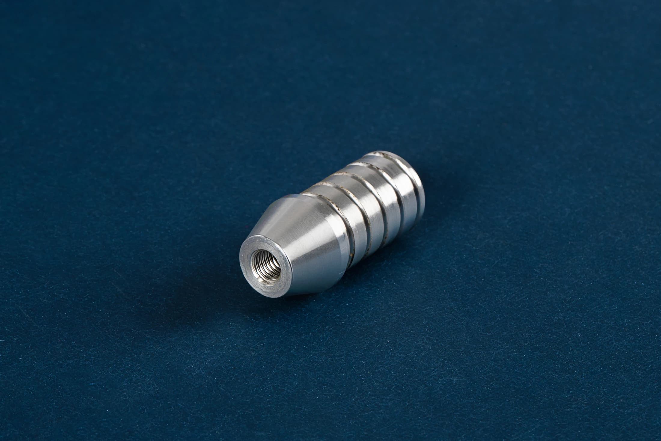 Grooved cylindrical part on a dark blue background